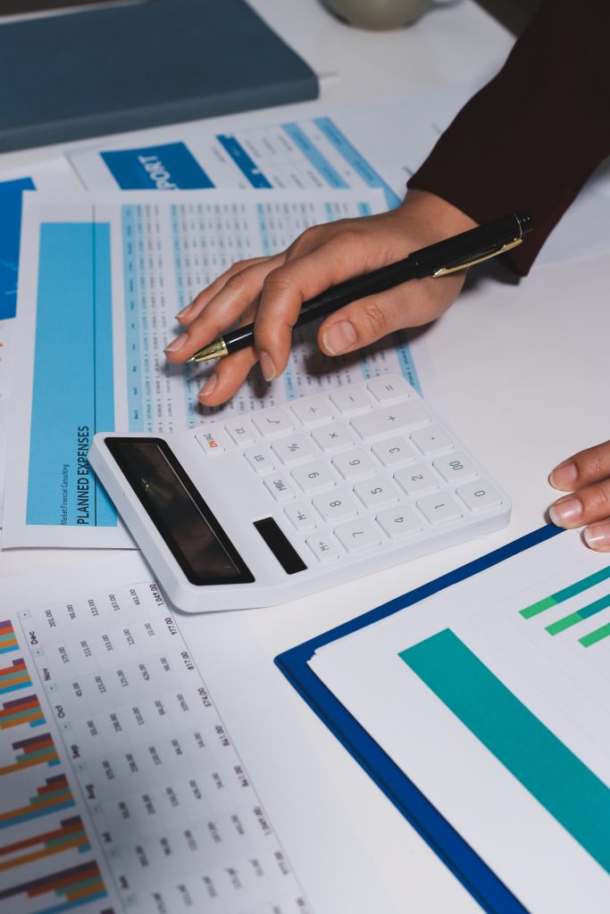 Professional using a calculator to review tax and expense figures